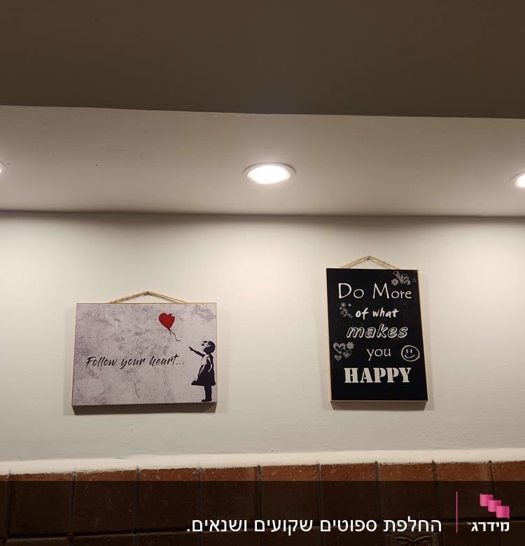 שלושה פנסי תקרה מוארים על קיר לבן